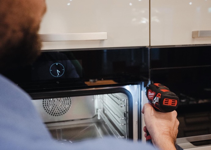 Servicio de reparación Técnico reparando un horno